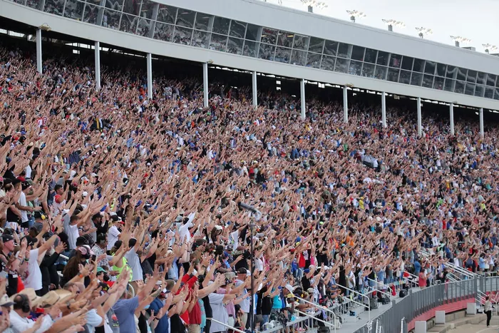 Los aficionados hacen el gesto del número 8 en apoyo a Kyle Busch