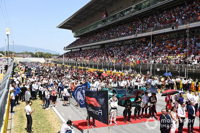 La dirección de la F1, los dignatarios, los invitados y los pilotos se sitúan en la parrilla para escuchar el himno nacional antes de la salida 