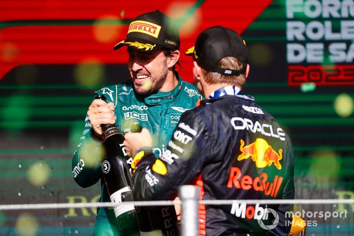 Fernando Alonso, Aston Martin F1 Team, 3ª posición, Max Verstappen, Red Bull Racing, 1ª posición, lo celebran rociando champán en el podio.