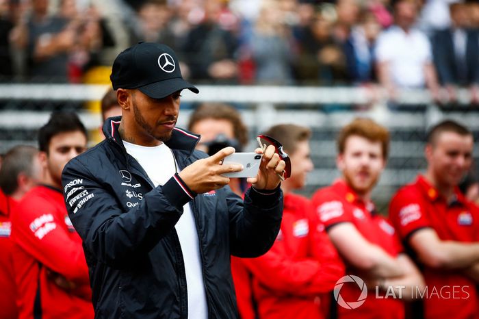 Lewis Hamilton, Mercedes AMG F1, takes a picture of junior garters