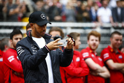 Lewis Hamilton, Mercedes AMG F1, takes a picture of junior garters