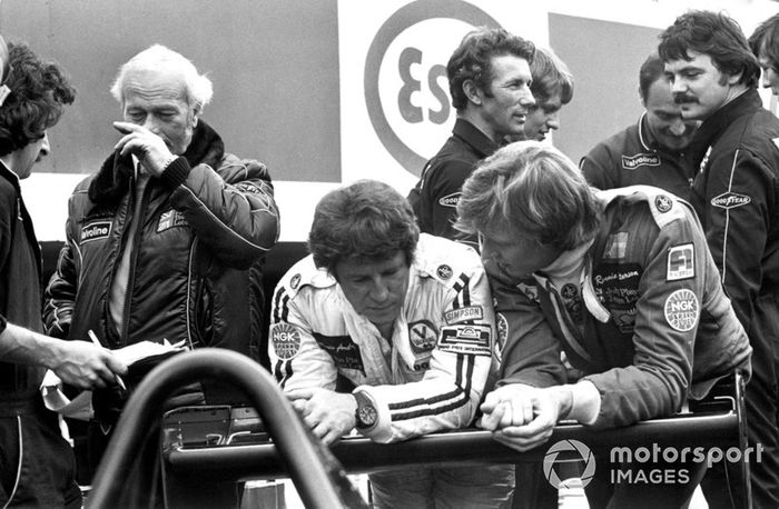 Mario Andretti y Ronnie Peterson hablan en el pit lane en presencia del jefe del equipo Colin Chapman, Lotus
