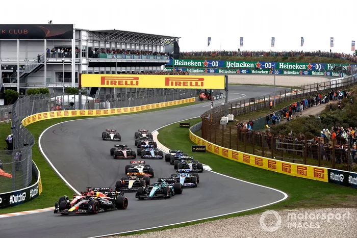 Sergio Pérez, Red Bull Racing RB19, Charles Leclerc, Ferrari SF-23, Lance Stroll, Aston Martin AMR23, Oscar Piastri, McLaren MCL60, el resto de la parrilla en la primera vuelta.