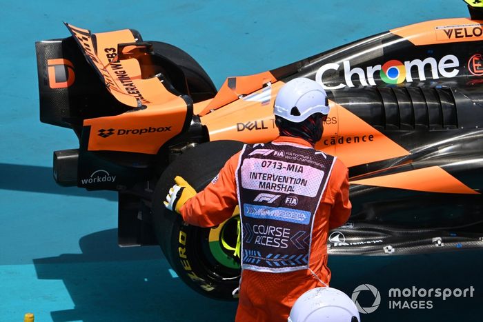 Los comisarios retiran el coche de Lando Norris, McLaren MCL38, después de que hiciera un trompo en la primera vuelta