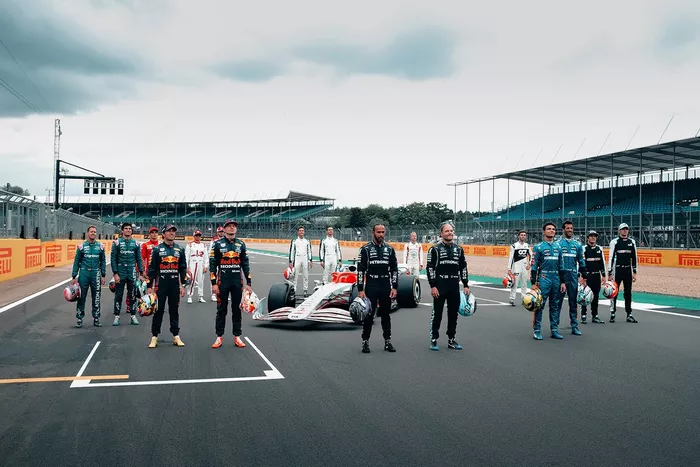 Foto de grupo de los pilotos con el coche de F1 de 2022