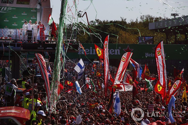 Confetti and streamers fall around the huge crowd of Ferrari fans gathered for the podium ceremony