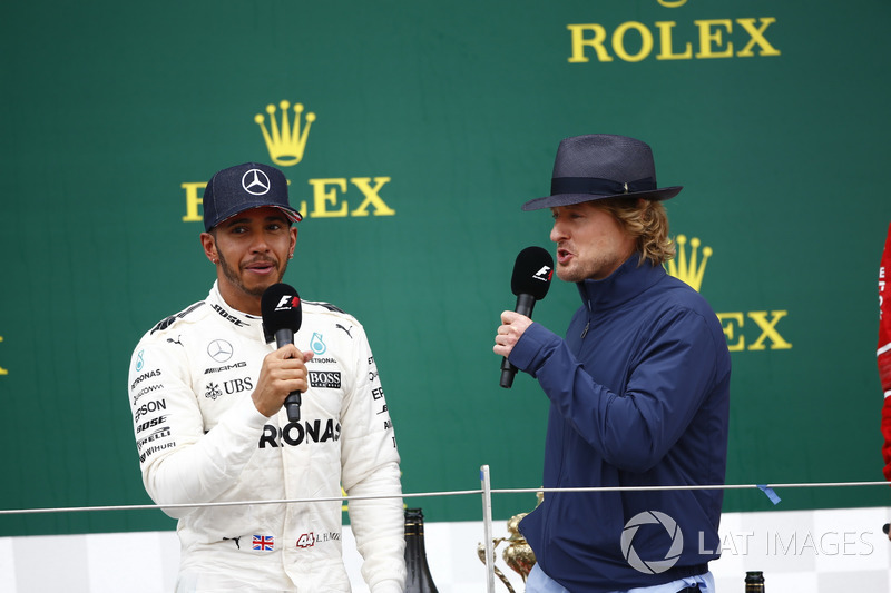 Actor Owen Wilson interviews Race winner Lewis Hamilton, Mercedes AMG F1, on the podium