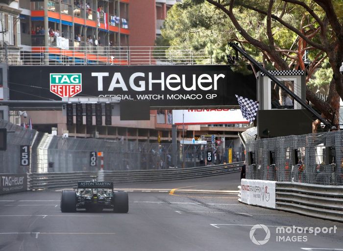 Sebastian Vettel, Aston Martin AMR21, cruza la línea de meta mientras Serena Williams ondea la bandera a cuadros