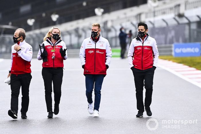 Mick Schumacher, Alfa Romeo, recorre la pista con miembros del equipo