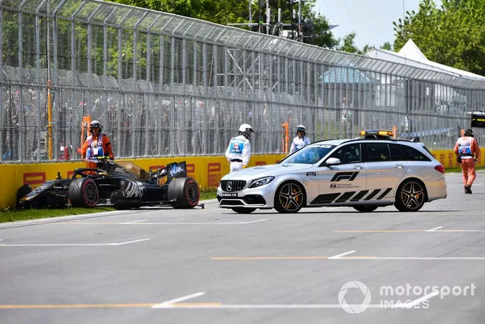 El coche médico y los oficiales atienden al coche dañado de Kevin Magnussen, Haas VF-19, después del segundo trimestre.