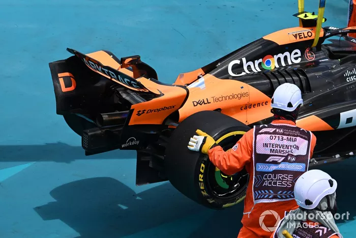 Los comisarios retiran el coche de Lando Norris, McLaren MCL38, después de que hiciera un trompo en la primera vuelta
