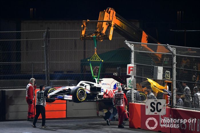 Oficiales de pista retiran el coche dañado de Mick Schumacher, Haas VF-21, del circuito
