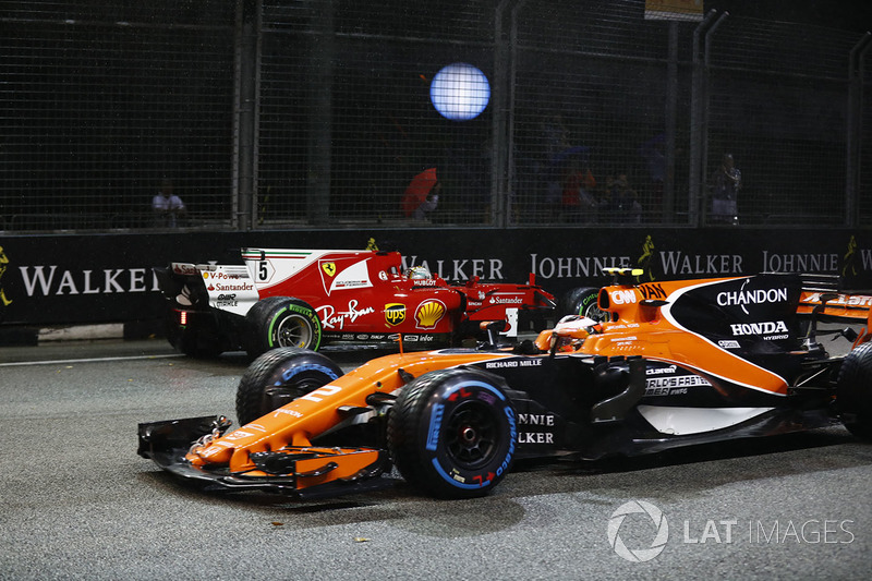 Stoffel Vandoorne, McLaren MCL32, passes the crashed car of Sebastian Vettel, Ferrari SF70H