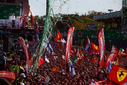 Confeti cae alrededor de la multitud de fans de Ferrari que se reunieron para la ceremonia de podio