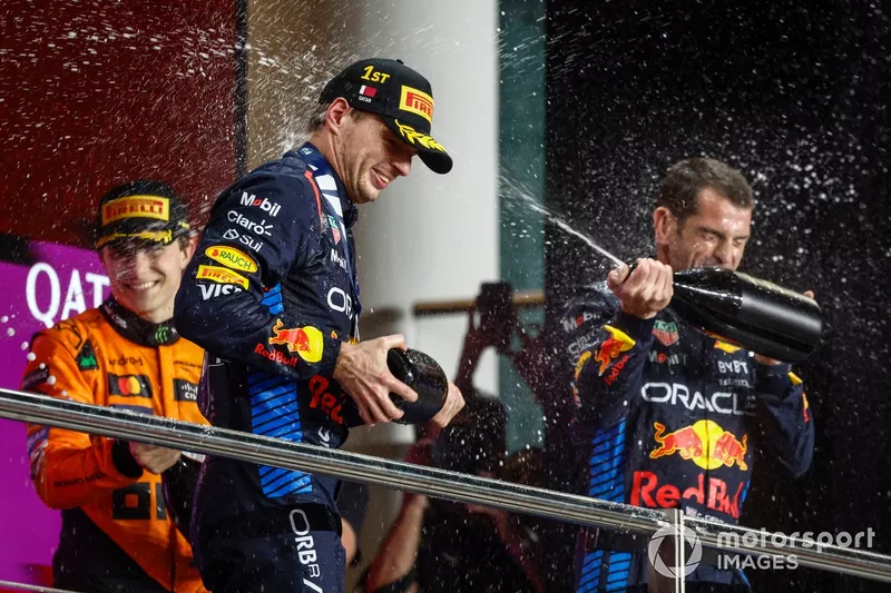 Max Verstappen, Red Bull Racing, 1ère position, Oscar Piastri, McLaren F1 Team, 3ème position, le délégué Red Bull Racing sur le podium arrose le champagne pour célébrer.