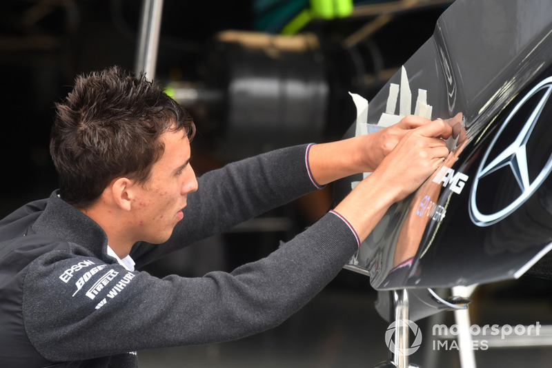 Un mécanicien de Mercedes-AMG F1 applique le logo de l'équipe sur la carrosserie d'une Mercedes W09