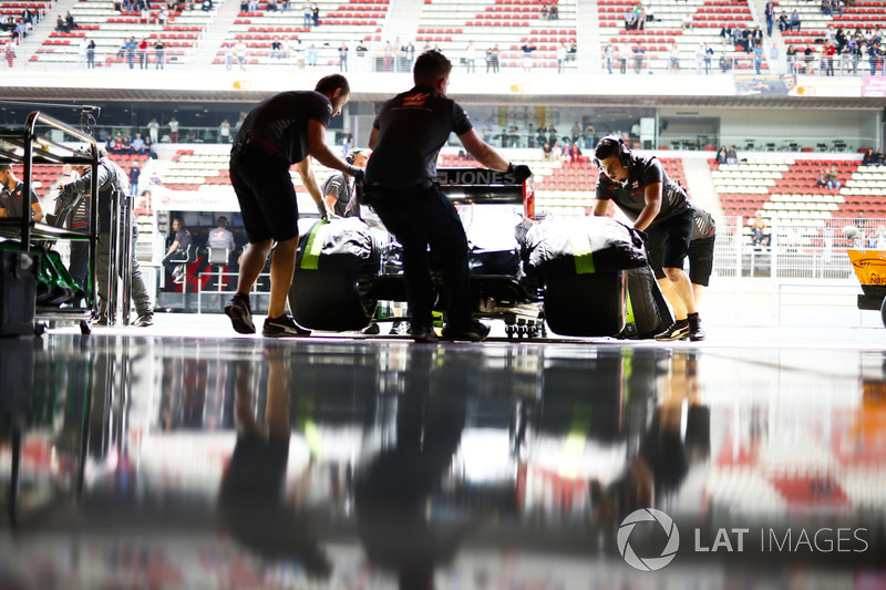 Engineers return Romain Grosjean, Haas F1 Team VF-18, to the garage