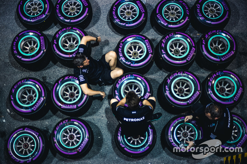 Mecánicos de Mercedes sentados sobre neumáticos Pirelli