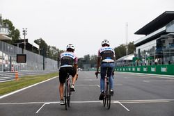 Esteban Ocon, Force India y Sergio Pérez, Force India, andan por el circuito en bicicleta