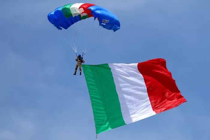 parachutist arrives flying the Italian flag
