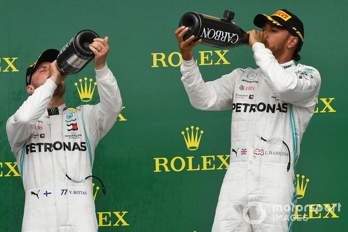 Valtteri Bottas, Mercedes AMG F1, 2nd position, and Lewis Hamilton, Mercedes AMG F1, 1st position, drink Champagne on the podium