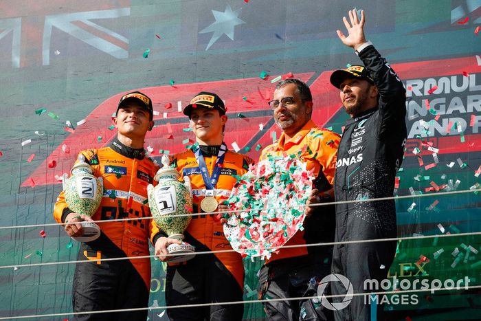 Lando Norris, McLaren F1 Team, 2ª posición, Oscar Piastri, McLaren F1 Team, 1ª posición, el delegado del trofeo McLaren y Lewis Hamilton, Mercedes-AMG F1 Team, 3ª posición, en el podio.