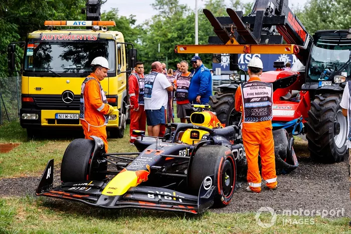 Los comisarios con el coche dañado de Sergio Pérez, Red Bull Racing RB20