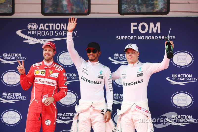 Lewis Hamilton, Mercedes AMG, celebrates taking pole position alongside Sebastian Vettel, Ferrari an