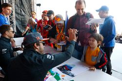 Fernando Alonso, McLaren, dar una palmadita a un joven fan, Stoffel Vandoorne, McLaren, firma autógrafos