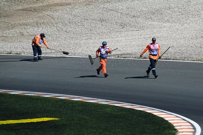 Los comisarios limpian la pista durante la sesión de clasificación del Gran Premio de Holanda de Fórmula Uno en el circuito de Zandvoort, al oeste de Holanda, el 30 de agosto de 2025. (Foto de NICOLAS TUCAT / AFP)