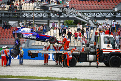 Marshals remove the damaged car of Brendon Hartley, Toro Rosso STR13, from the circuit as the gearbox hangs off the back