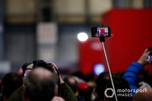 Un fan toma una fotografía de Charles Leclerc siendo entrevistado en el escenario de Autosport
