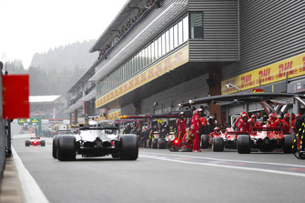 Kimi Raikkonen, Ferrari SF71H, and Sebastian Vettel, Ferrari SF71H, make pit stops for intermediate tyres, as Romain Grosjean, Haas F1 Team VF-18, passes by