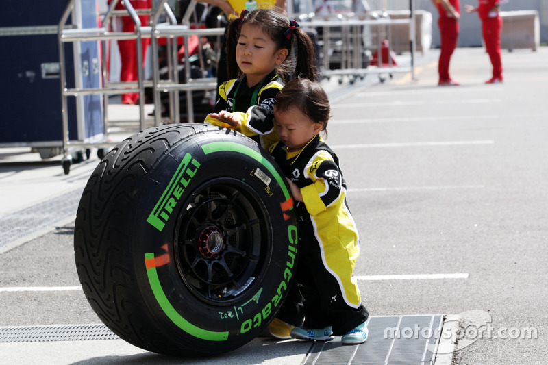 Fans jóvenes de Renault Sport F1 Team con un neumático de Pirelli