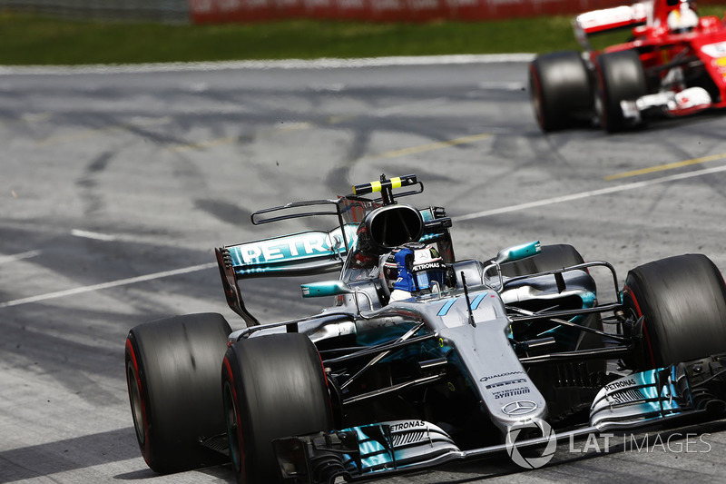 Valtteri Bottas, Mercedes AMG F1 W08, raises an arm in victory celebration at the finish, ahead of Sebastian Vettel, Ferrari SF70H