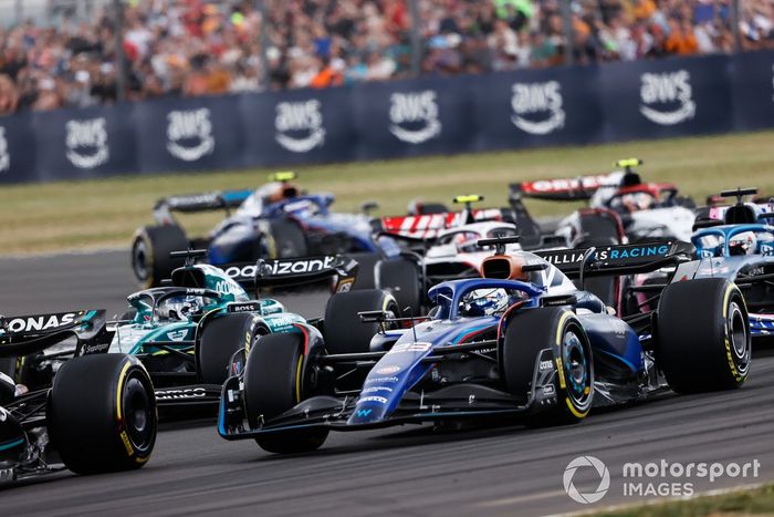 Alex Albon, Williams FW45, Lance Stroll, Aston Martin AMR23, Esteban Ocon, Alpine A523, el resto de la parrilla en la primera vuelta.