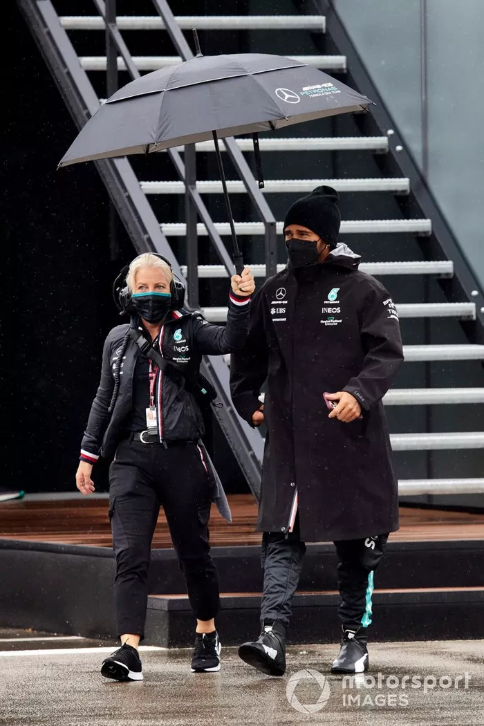 Angela Cullen, fisioterapeuta de Lewis Hamilton, sostiene un paraguas sobre Lewis Hamilton, Mercedes