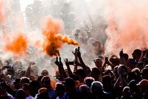 Fans set off orange smoke flares in the grandstands