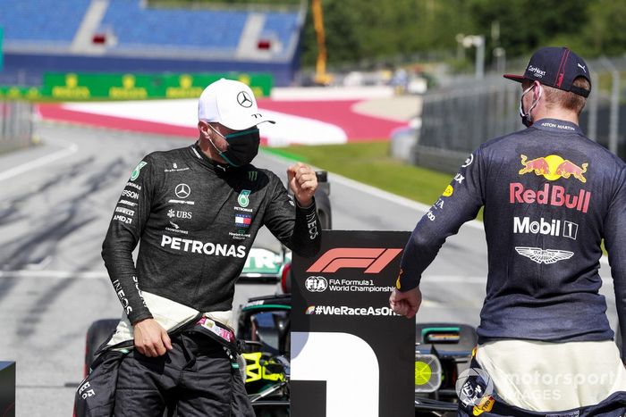 Pole man Valtteri Bottas, Mercedes-AMG Petronas F1, e Max Verstappen, Red Bull Racing, sulla griglia di partenza dopo la qualifica