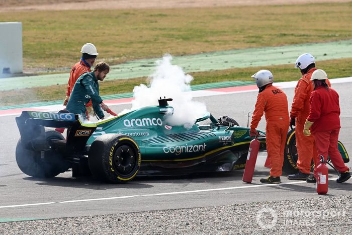 Oficiales de pista asisten a Sebastian Vettel, Aston Martin AMR22, después de que un fallo técnico produzca humo