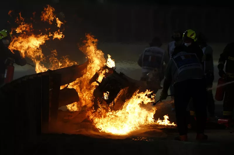 Marshals extinguish the flames after a big crash for Romain Grosjean, Haas VF-20, on the opening lap
