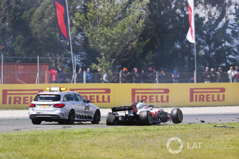 Una macchina ufficiale ferma accanto alla monoposto incidentata di Romain Grosjean Haas F1 Team VF-18