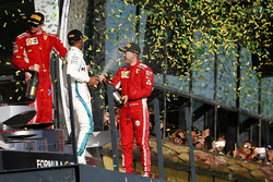 Kimi Raikkonen, Ferrari, 3° classificato, Lewis Hamilton, Mercedes AMG F1, 2° classificato, e Sebastian Vettel, Ferrari, 1° classificato, festeggiano con lo Champagne sul podio