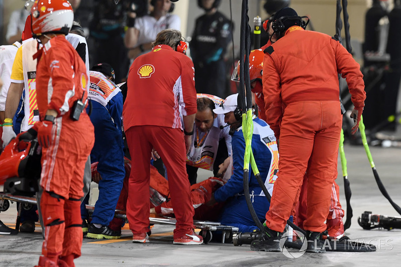 Un mécanicien Ferrari pris en charge par les services médicaux après avoir été percuté par Kimi Raikkonen, Ferrari SF71H pendant un arrêt au stand