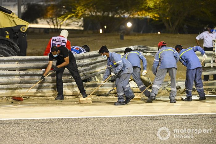 Los oficiales retiran los restos después del choque de Romain Grosjean, Haas VF-20, en la primera vuelta