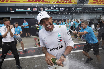 Lewis Hamilton, Mercedes AMG F1, sprays champagne in celebration of victory