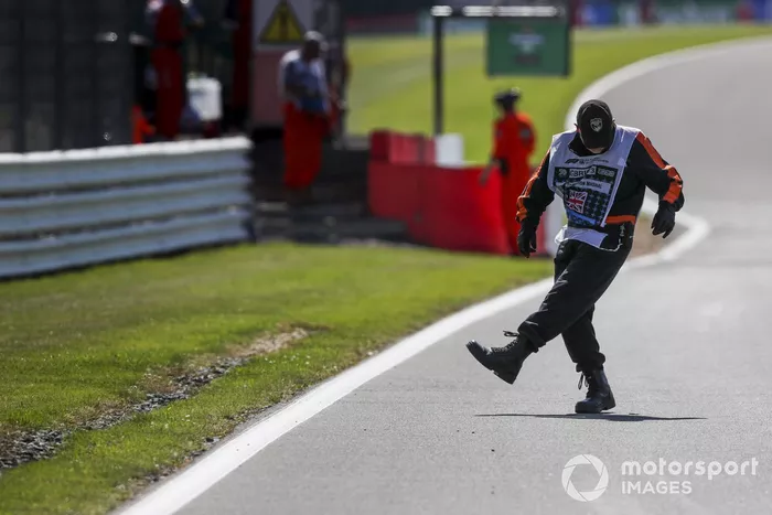 Un oficial de pista saca algunos escombros del circuito