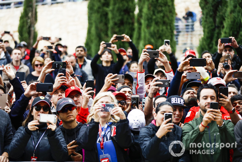 Fans take photos of the drivers with their mobile phones