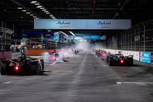 The cars smoke their tyres as they pull away at the start