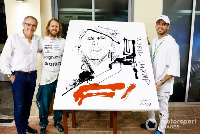 El artista Sr. Dripping y Stefano Domenicali, director general de la Fórmula 1, presentan un cuadro a Sebastian Vettel, Aston Martin